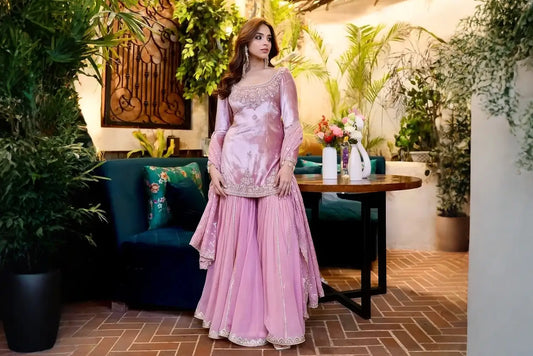 A pastel pink sharara set with intricate embroidery, blending traditional charm with refined elegance, perfect for festive and formal occasions.