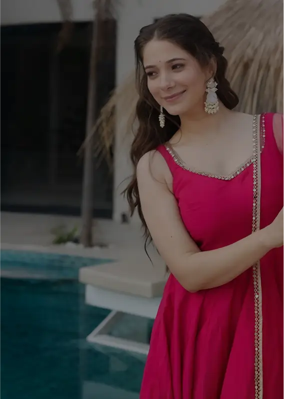 Woman in a pink dress standing by a pool
