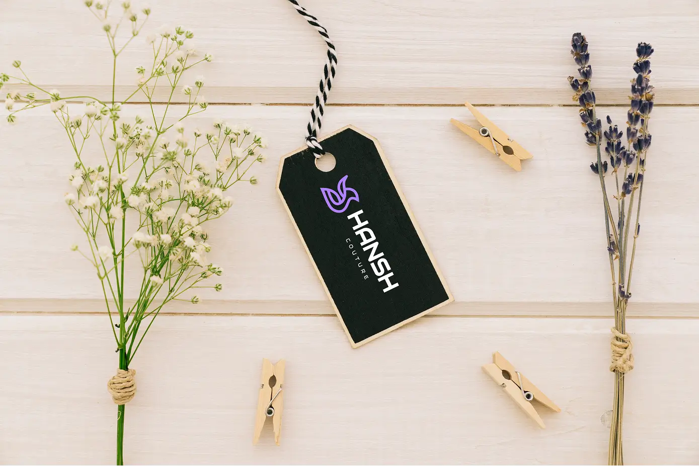 Hansh tag with flowers and clothespins on a wooden surface
