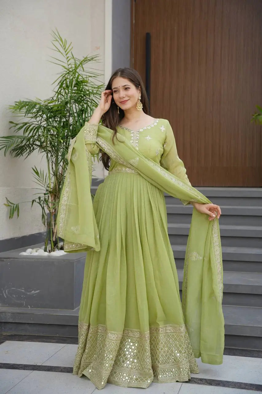 silk gown dress with dupatta New catalog , This elegant space silk gown features a flared silhouette and details on the sleeves, adding texture and sophistication. Paired with a contrast-colored zari embroidered and scalloped