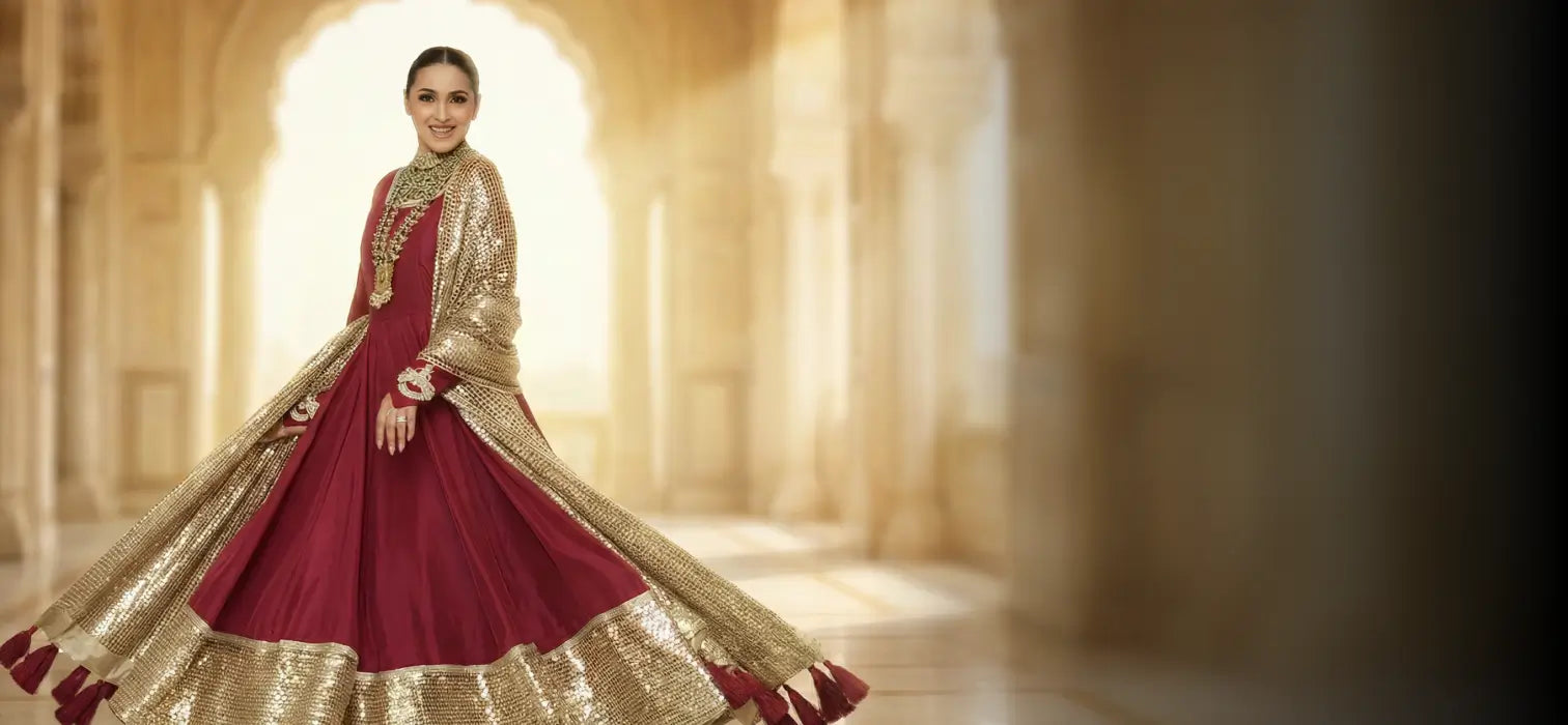 Magenta embroidered festive Anarkali dress styled with golden wedding decor and floral backdrop, luxury ethnic fashion banner.