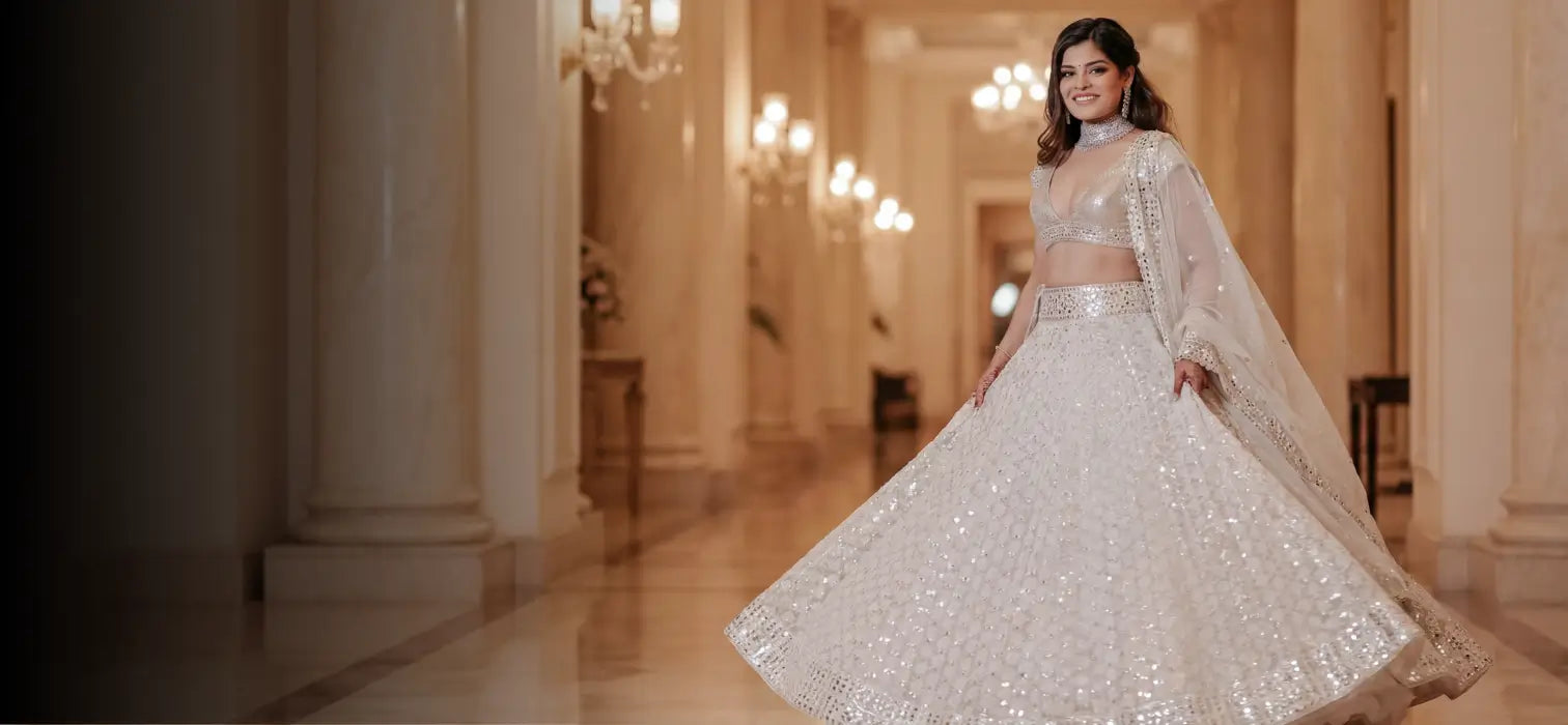 White mirror embroidered bridal lehenga with shimmering skirt flare, styled in a luxury grand hall interior, right-aligned couture hero banner.