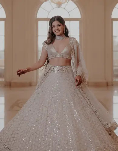 White georgette mirror work lehenga with embellished blouse and dupatta, styled in premium palace hall for mobile hero display.